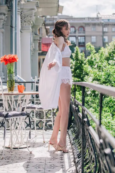 Genç, narin, güzel gelin sabah düğün balkonda güzel beyaz dantelli iç çamaşırlarıyla dikilmeden önce. Yüksek kalite fotoğraf