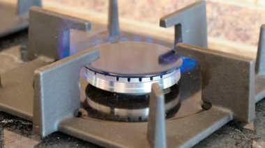 Mutfak sobasında yanan gazın parlak mavi alevini kapat.