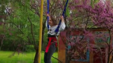 Rivne, Ukraine, May 14, 2022: Joyful little girl jumping on a banjo trampoline ride in a leisure park
