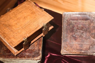 Ancient books in leather binding with copper locks on the table