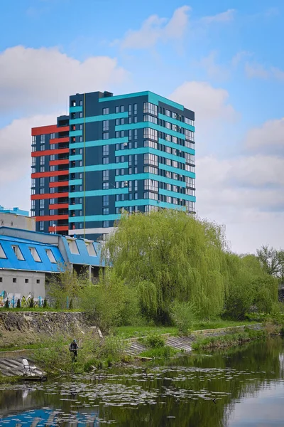 stock image Rivne, Ukraine, May 5, 2022: Modern high-rise residential building on the banks of the river