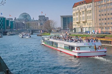 Berlin, Almanya - 7 Nisan 2019: Berlin 'deki Spree' de Bundestag ve Reichstag manzaralı bir eğlence teknesi