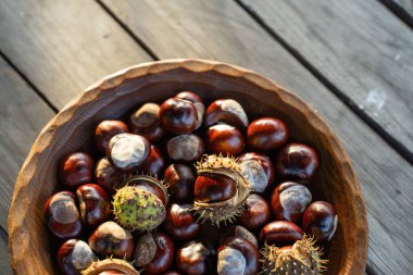 Tahta bir masadaki tahtadan bir kasede kestane