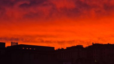 Cenova, İtalya-19 Kasım 2022: Gün batımlı günbatımı yansıması. Geceyarısı görkemli güneş batışıyla gökyüzü. Kırmızı ve turuncu renklerle renkli gün batımı..