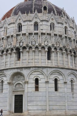 Pisa, İtalya - 25 Şubat 2023: Kış günlerinde Pisa şehrini keşfetmek. Arka planda gri gökyüzü olan Pisa Kulesi. İtalya 'nın eski ünlü mimarisi..