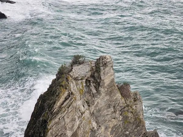 Corniglia, 5 Terre, İtalya - 05 Ocak 2024: Cinque Terre manzarasının güzel fotoğrafları. Kış günlerinde arka planda mavi gökyüzü olan dalgaların muhteşem manzarası. Günbatımı renkleri.
