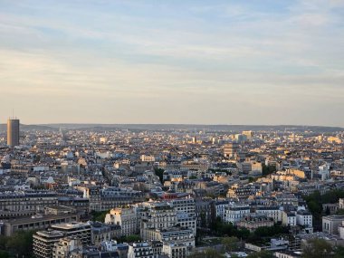 Paris, Fransa - 12 Nisan 2024: Modern gökdelenler ve eski binalar arasındaki altın saat boyunca Paris şehrine havadan bakış. Şehrin üzerinde güzel bir gün batımı yansıyor binalara.