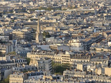 Paris, Fransa - 12 Nisan 2024: Modern gökdelenler ve eski binalar arasındaki altın saat boyunca Paris şehrine havadan bakış. Şehrin üzerinde güzel bir gün batımı yansıyor binalara.