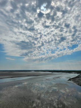 Mont Saint Michel, Fransa - 20 Mayıs 2024: Baharda Saint Michel Normandiya 'dan güzel manzara. Gökyüzü renkleri suya yansıdı. İlk güneşli günlerinde yeşil arazi.