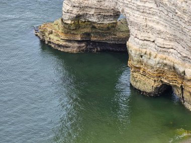 Normandiya, Fransa - 18 Mayıs 2024: Etretat uçurumlarındaki resimli panoramik manzara. Doğal muhteşem uçurumlar. Etretat, Normandiya, Fransa, La Manche veya Manş Denizi. Güneşli yaz gününde Pays de Caux bölgesinin kıyısında. Fransa