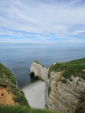 Normandiya, Fransa - 18 Mayıs 2024: Etretat uçurumlarındaki resimli panoramik manzara. Doğal muhteşem uçurumlar. Etretat, Normandiya, Fransa, La Manche veya Manş Denizi. Güneşli yaz gününde Pays de Caux bölgesinin kıyısında. Fransa