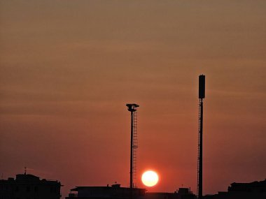 Cenova, İtalya - 07 Kasım 2024: Sonbahar günlerinde şehrin üzerinde güzel kırmızı gökyüzü. Güneşin altın saatinde zum yaptı.