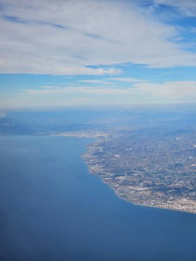 İspanya, 09 Ekim 2024 İspanya kıyılarındaki dağlarda yüksek uçuş. Şehirlere, deniz kenarlarına ve dağlara insansız hava aracı görüntüsü. Bulutlardan güzel manzara.