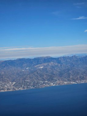 İspanya, 09 Ekim 2024 İspanya kıyılarındaki dağlarda yüksek uçuş. Şehirlere, deniz kenarlarına ve dağlara insansız hava aracı görüntüsü. Bulutlardan güzel manzara.