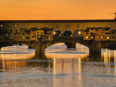 Floransa, İtalya - 5 Ekim 2024: Piazzale Michelangelo 'dan altın gün batımında Floransa' nın nefes kesici manzarası. Duomo, Vecchio Sarayı ve diğer Rönesans simgeleri sıcak akşam günbatımında güneşlenirler.