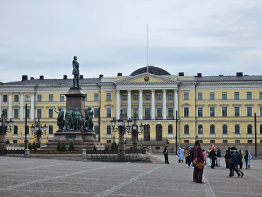 Finlandiya, Helsinki - 11 Mart 2025: Helsinki şehrini kış günlerinde keşfetmek. Şehrin eski limanını geziyorum. Bulutlu gökyüzü Kuzey Denizi 'ne yansıyor.