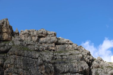 Trentino, İtalya - 29 Temmuz 2025: Piz Boe 'nun görkemli panoramik manzarası ve çevreleyen Dolomite tepeleri, yemyeşil vadiler ve açık mavi bir gökyüzü altında dağınık kar. Boe Gölü 'ne güzel bir manzara, ve su üzerinde gökyüzü yansıması..