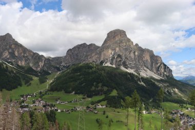 Trentino, İtalya - 29 Temmuz 2025: Piz Boe 'nun görkemli panoramik manzarası ve çevreleyen Dolomite tepeleri, yemyeşil vadiler ve açık mavi bir gökyüzü altında dağınık kar. Boe Gölü 'ne güzel bir manzara, ve su üzerinde gökyüzü yansıması..