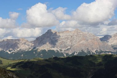 Trentino, İtalya - 29 Temmuz 2025: Piz Boe 'nun görkemli panoramik manzarası ve çevreleyen Dolomite tepeleri, yemyeşil vadiler ve açık mavi bir gökyüzü altında dağınık kar. Boe Gölü 'ne güzel bir manzara, ve su üzerinde gökyüzü yansıması..