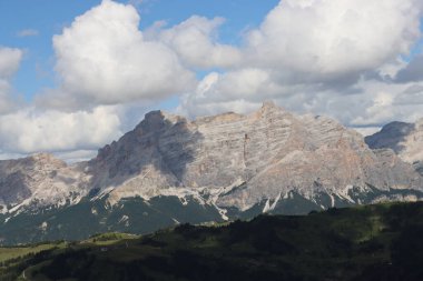 Trentino, İtalya - 29 Temmuz 2025: Piz Boe 'nun görkemli panoramik manzarası ve çevreleyen Dolomite tepeleri, yemyeşil vadiler ve açık mavi bir gökyüzü altında dağınık kar. Boe Gölü 'ne güzel bir manzara, ve su üzerinde gökyüzü yansıması..