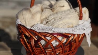 Sepette örgü iplikleri, örgü iğneleri ve iplik yumağı var..