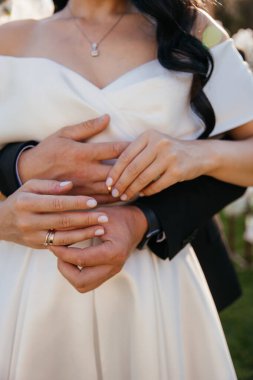 Gelinin ve damadın elleri bir kucaklaşmada yüzükleri değiş tokuş eder