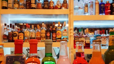 içecekler bar şişelerinde. Arka planda birçok renk ışığı var. 