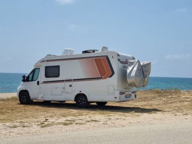 Yaz tatilinde sahildeki karavan arabası modern deniz mavisi gökyüzü