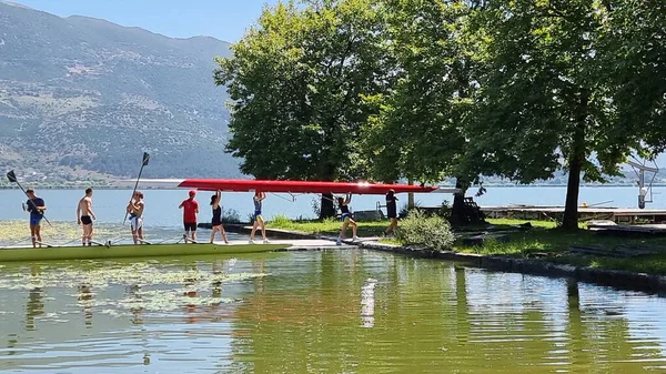 Kürek çeken kürekçiler yaz mevsiminde ioannina ağaçlarının altında Pamvotis Gölü 'nde antrenman yapıyorlar.