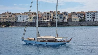 Yunan Korfu şehri yelkenlisi evlerin önünde yaz tatili yelken açıyor.