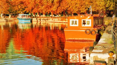 Sonbaharda ioannina ya da Giannena sesaon gölü ağaçları tekneler mavi gökyüzü yansımaları Yunanistan