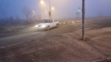 Ioannina 'da kış mevsiminde sabah hareket eden sisli trafik ışıkları.