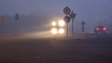 Ioannina 'da kış mevsiminde sabah hareket eden sisli trafik ışıkları.