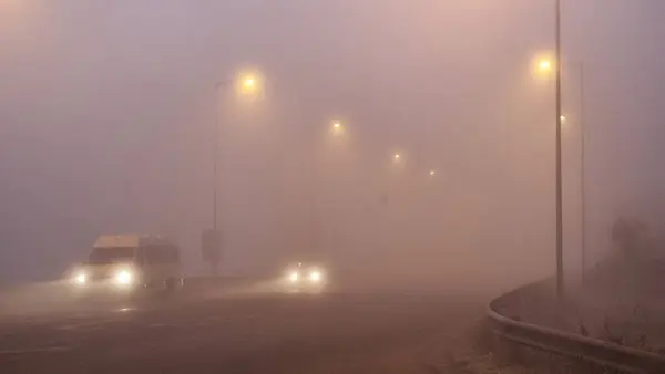 foggy road traffic lights cars moving in the morning in ioannina greece winter season