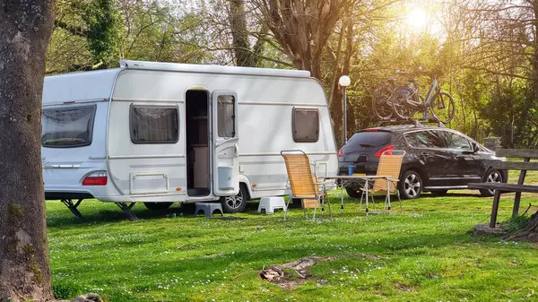 Karavan karavanı bahar mevsiminde göl çimlerinin yanında. 