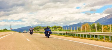 Morobike motosikleti Yunanistan bahar sezonunda bulutlu bir günde asfalt yolda hız yapıyor.