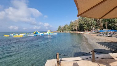 preveza kiani akti beach sea trees umbrellas sandy beach extreme sprorts in holidays clipart