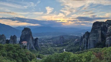 Kalampaka 'daki meteora kiliseleri. Günbatımı bulutları gün batımını renklendiriyor.