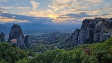 Kalampaka 'daki meteora kiliseleri. Günbatımı bulutları gün batımını renklendiriyor.