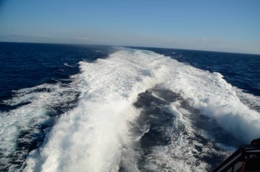 Geminin köpük dalgaları yazın Yunan Mykonos adalarında dolaşır.