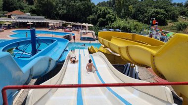 Su parkı su kaydırağı yaz mevsiminde çocuklar için oynayıp yüzüyor.