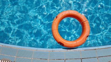 Yüzme havuzunda turuncu bir halka, berrak mavi bir su.