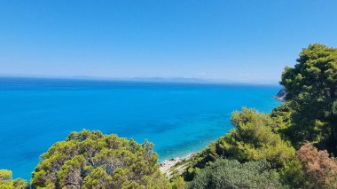 Solda, Yunan adasında yaz tatili için mavi gökyüzü ağacı