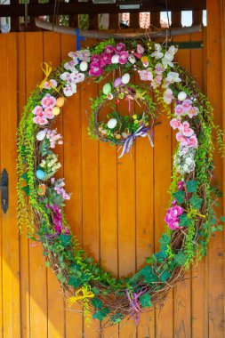 Easter Eggs wreath with flowers on front door. Traditional decoration for Easter. . High quality photo