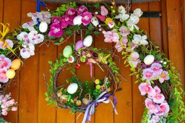 Easter Eggs wreath with flowers on front door. Traditional decoration for Easter. . High quality photo