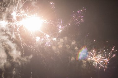 Grmitz sahilinin yukarısında ışıltılı bir havai fişek gösterisi. Gece gökyüzünü aydınlatan parlak havai fişekler