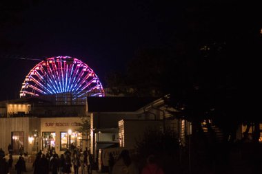  Akşamları parlayan renkli ışıkları olan dönme dolap. Gece karnavalında neon ışıklı dönme dolap..