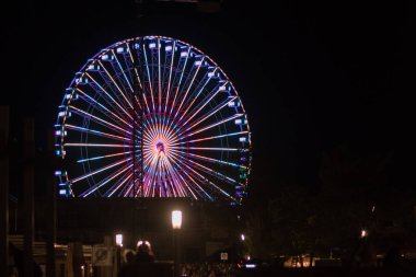 Karanlık gökyüzünde parlayan lunapark dönme dolabı. Grmitz, Almanya 'da parıldayan ışık yansımaları olan güzel bir dönme dolap.