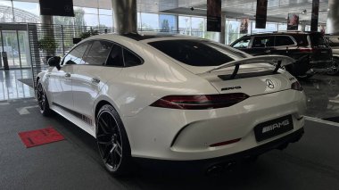 Lüks beyaz coupe Mercedes-Benz G-Sınıfı arkada görünüyor.