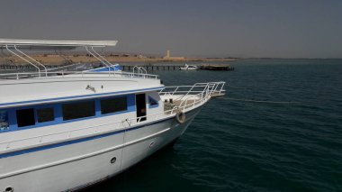 Beyaz yat, sakin tropikal sular ve berrak gökyüzü ile çevrili, Mısır 'ın pitoresk deniz manzarasında dinleniyor.